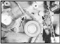 19.5 Timing belt tensioner bolts (arrowed) - models from mid-1985