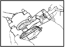 4.9 Using a spreader tool to depress the caliper piston into its bore